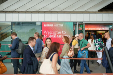ECTRIMS Milan 2023 poster and people in front of it